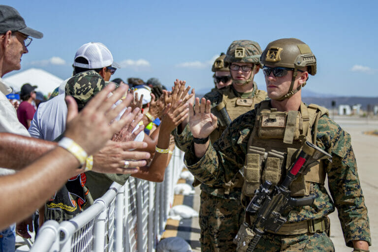 U.S. Marines with 3rd Battalion, 5th Marines, 1st Marine Division, high five the audience after the Marine Air-Ground Task Force demonstration of the 2022 Marine Corps Air Station Miramar Air Show at MCAS Miramar, San Diego, California, Sept. 24, 2022. The MAGTF Demo displays the coordinated use of close-air support, artillery and infantry forces, and provides a visual representation of how the Marine Corps operates. The theme for the 2022 MCAS Miramar Air Show, “Marines Fight, Evolve and Win,” reflects the Marine Corps’ ongoing modernization efforts to prepare for future conflicts. (U.S. Marine Corps photo by Lance Cpl. Zachary Larsen)